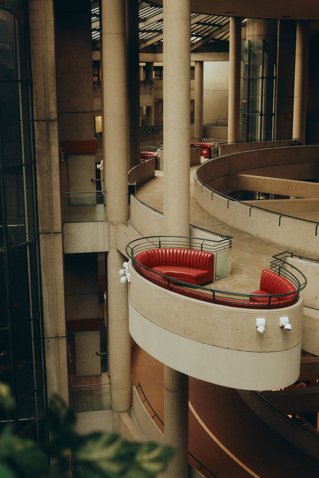 Brutalist concrete interior with a curved balcony and raw board-formed surfaces