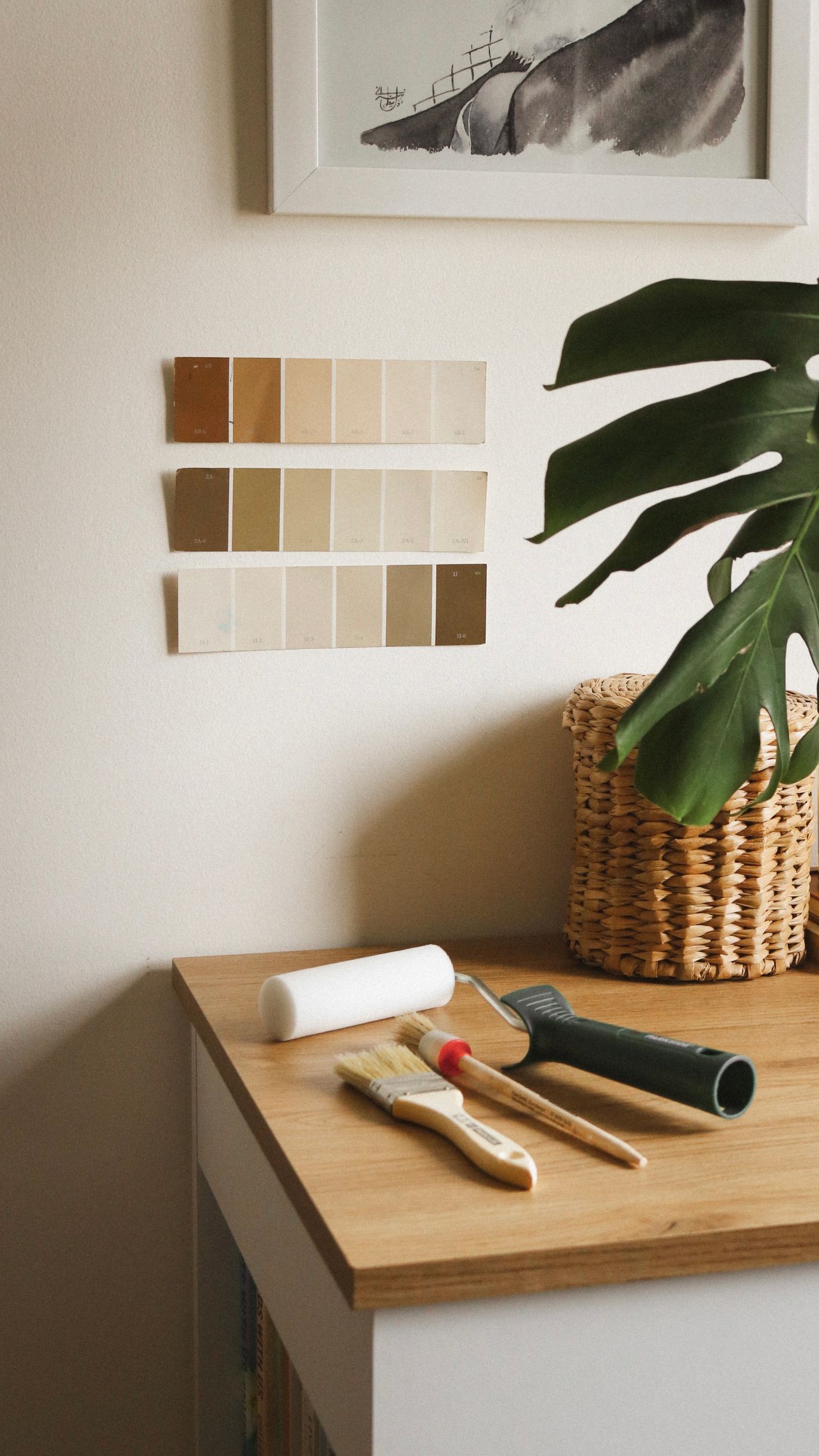 Earthy interior paint colour swatches laid out with paint brushes