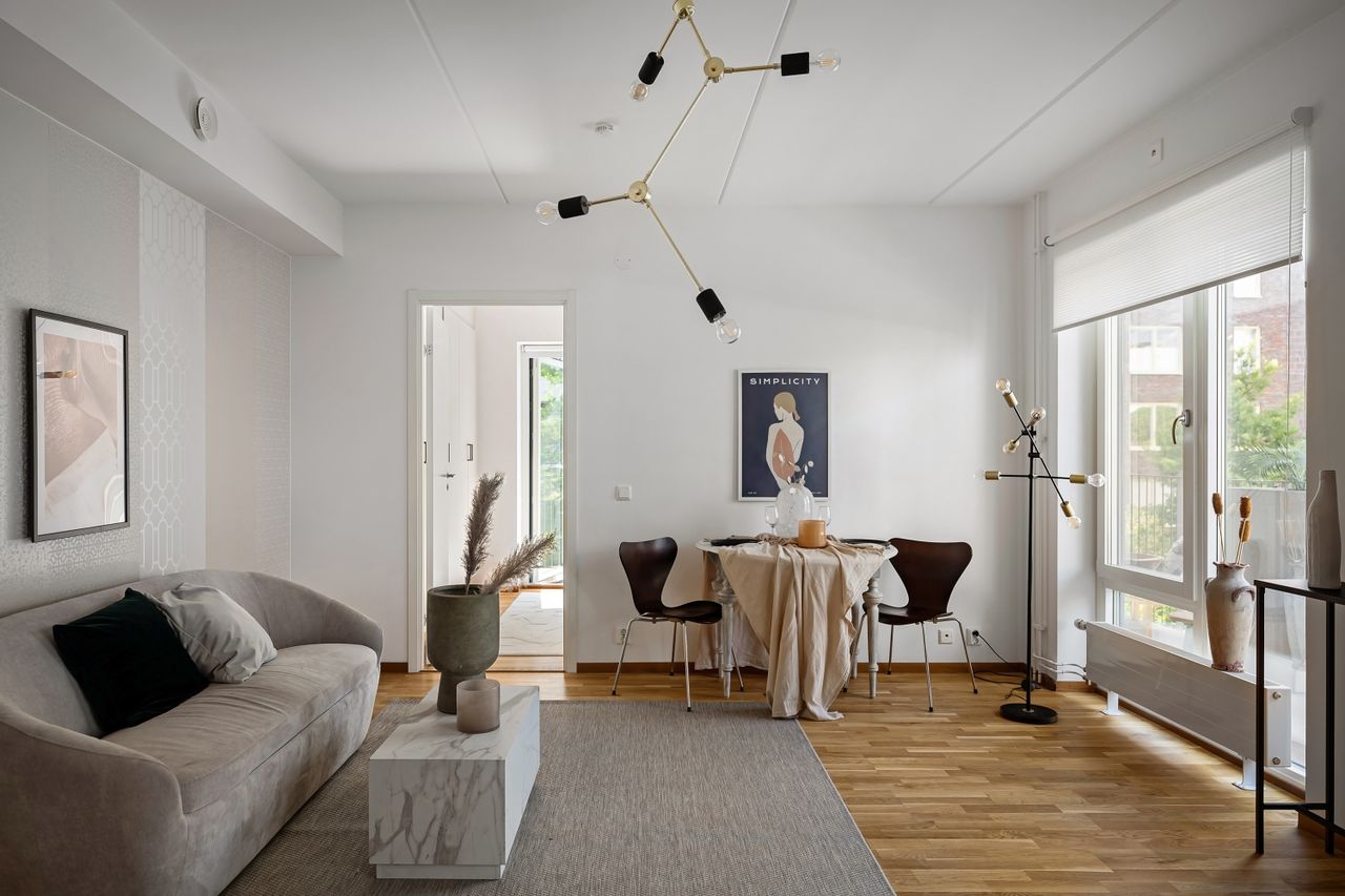 Minimal warm-neutral living and dining room with natural light and an oak dining table